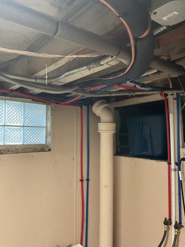 Completed full installation of a 14 SEER 2-ton package air conditioning unit with new copper refrigerant line set (3/4" x 20'), concrete equipment pad, electrical disconnect box with whip, and Honeywell T6 Pro thermostat. The outdoor unit was positioned on the new pad against the exterior wall with proper clearances, connected to the electrical disconnect via conduit, and refrigerant lines were routed through the wall to connect with the indoor coil system. Interior copper refrigerant lines were professionally installed and secured along the basement ceiling infrastructure, integrating with the existing HVAC ductwork and mechanical systems. All electrical connections were completed to code, the system was charged with refrigerant, and startup procedures verified proper operation of the compressor, fan motor, and thermostat controls.