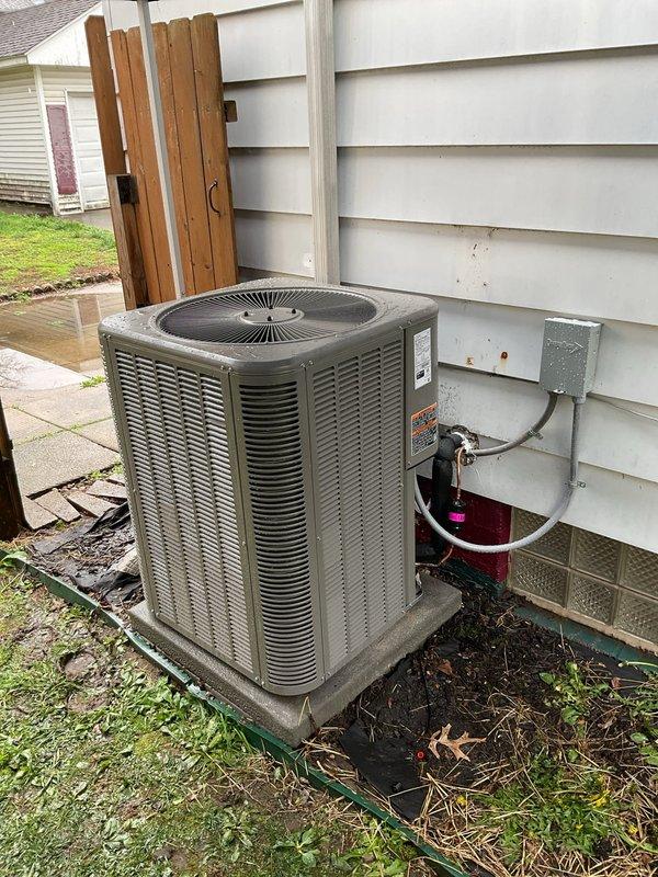 Completed full installation of a 14 SEER 2-ton package air conditioning unit with new copper refrigerant line set (3/4" x 20'), concrete equipment pad, electrical disconnect box with whip, and Honeywell T6 Pro thermostat. The outdoor unit was positioned on the new pad against the exterior wall with proper clearances, connected to the electrical disconnect via conduit, and refrigerant lines were routed through the wall to connect with the indoor coil system. Interior copper refrigerant lines were professionally installed and secured along the basement ceiling infrastructure, integrating with the existing HVAC ductwork and mechanical systems. All electrical connections were completed to code, the system was charged with refrigerant, and startup procedures verified proper operation of the compressor, fan motor, and thermostat controls.