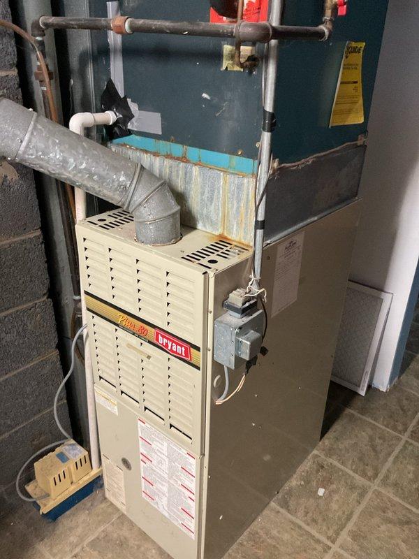 Completed comprehensive estimate for full HVAC system replacement including outdoor condensing unit and indoor furnace/air handler assembly. Outdoor unit shows significant age with weathered concrete pad and deteriorating conditions, while indoor Bryant furnace and air handler exhibit visible wear, rust, and moisture damage around plenum connections. Provided detailed equipment specifications and replacement recommendations for complete system upgrade to restore efficient heating and cooling operation.