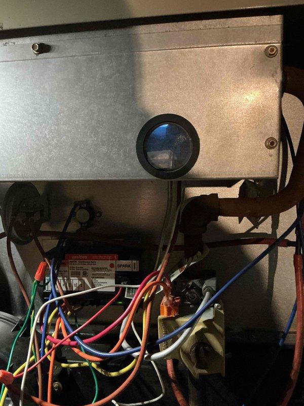 Responded to no-heat call on aging furnace system in basement reported to be blowing cold air. Upon inspection, found original equipment approximately 50 years old with significant rust and corrosion on metal components and brackets throughout the unit. Documented interior condition of furnace compartment, including blower motor assembly, electrical wiring connections, and visible deterioration of metal housing components for customer records and future service reference.