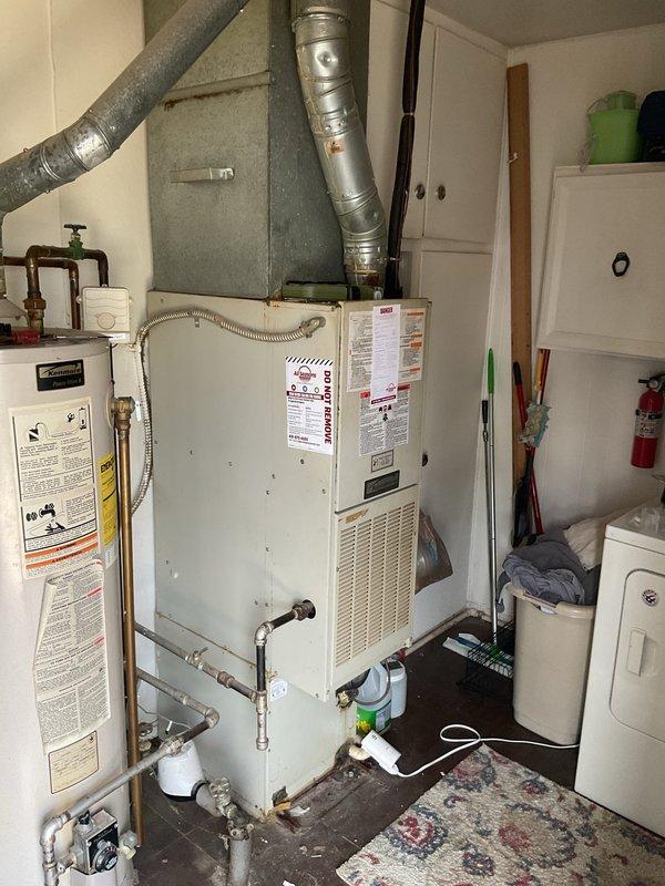 Completed comprehensive assessment of existing HVAC system for full replacement estimate. Evaluated current furnace unit located in utility room, documenting equipment specifications, ductwork configuration including both rigid metallic and insulated flexible sections, and clearances for replacement installation. Inspected exterior air conditioning condenser unit with associated electrical service including meter, disconnect box, and conduit routing along building exterior. Photographed all equipment, connections, and installation conditions to provide accurate replacement specifications and ensure proper sizing for new high-efficiency furnace and AC system.