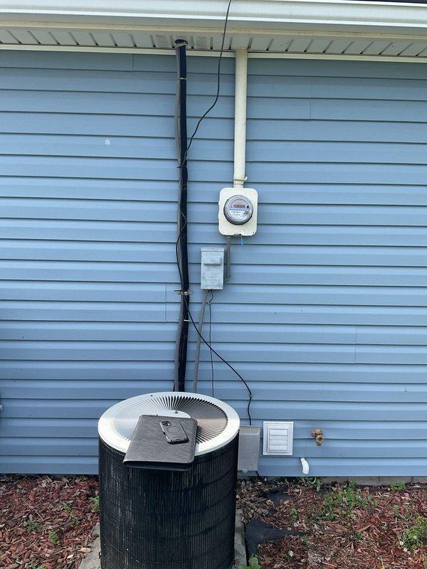 Completed comprehensive assessment of existing HVAC system for full replacement estimate. Evaluated current furnace unit located in utility room, documenting equipment specifications, ductwork configuration including both rigid metallic and insulated flexible sections, and clearances for replacement installation. Inspected exterior air conditioning condenser unit with associated electrical service including meter, disconnect box, and conduit routing along building exterior. Photographed all equipment, connections, and installation conditions to provide accurate replacement specifications and ensure proper sizing for new high-efficiency furnace and AC system.