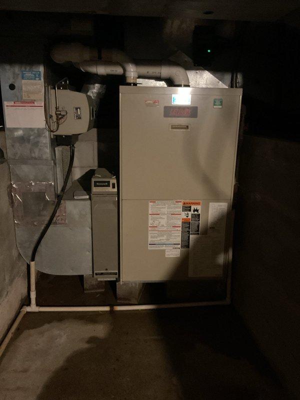 Responded to service call for furnace blowing cold air in basement. Upon inspection, found approximately 50-year-old original equipment furnace unit installed with connected ductwork and basement utilities. Evaluated existing HVAC system including indoor furnace unit and outdoor air conditioning condenser, documented equipment age and condition, and provided estimate for complete system replacement due to age and operational failure of heating equipment.