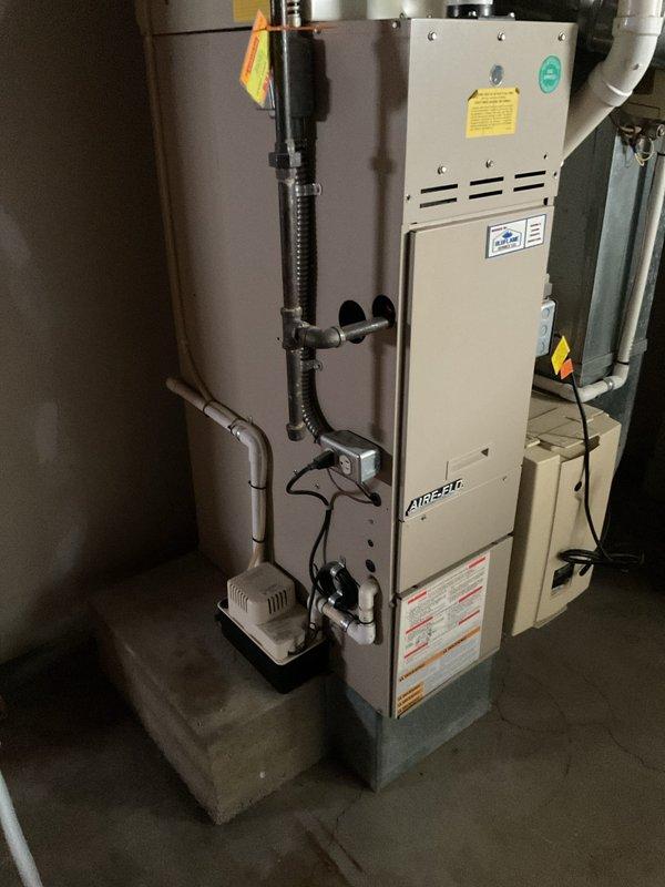 Completed comprehensive estimate for full HVAC system replacement including furnace and air conditioning condenser. The existing outdoor AC unit shows significant weathering and is located in an overgrown area with vegetation encroachment, while the indoor Amana furnace and associated equipment are currently operational but require replacement. Provided detailed assessment and replacement recommendations for both heating and cooling components.