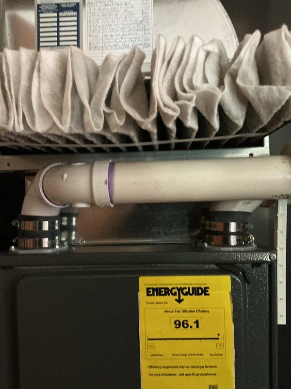 Performed routine cooling maintenance on a 23-year-old air conditioning system. Inspected electrical connections at the terminal block, verified wire integrity and terminal tightness, and examined the condensate drain line with proper mounting hardware. Documented system condition including flexible ductwork and reviewed unit efficiency rating of 96.1 AFUE displayed on the equipment label.