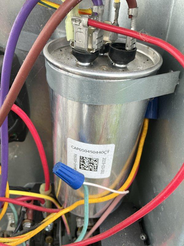 Performed spring maintenance on 10-year-old air conditioning system. Inspected and tested capacitor (CAP050450440CT) with all electrical connections secure and functioning properly. Used clamp meter to verify amperage draw on compressor unit, confirming system operating within normal parameters.