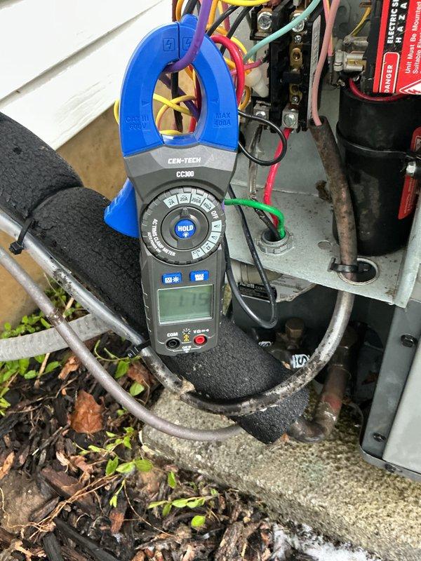 Performed spring maintenance on 10-year-old air conditioning system. Inspected and tested capacitor (CAP050450440CT) with all electrical connections secure and functioning properly. Used clamp meter to verify amperage draw on compressor unit, confirming system operating within normal parameters.