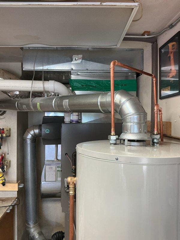 Completed installation of 40-gallon short tank water heater as part of a previously scheduled full system installation. Connected copper supply lines with proper fittings and verified level installation in mechanical room alongside existing HVAC equipment and ductwork.