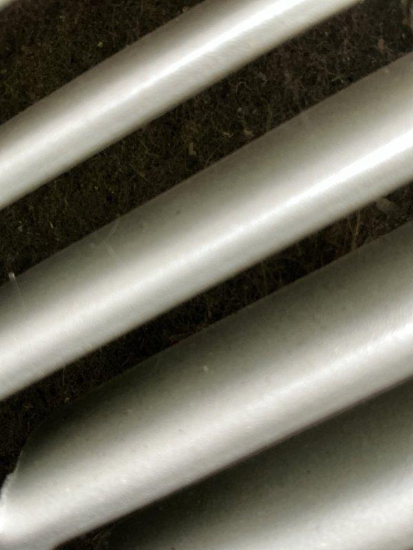 Performed routine maintenance on an 8-year-old air conditioning system. Inspected evaporator coil assembly and documented moderate dust and debris accumulation on heat exchanger fins and refrigerant lines. Completed standard tune-up procedures to ensure continued system efficiency and proper operation.