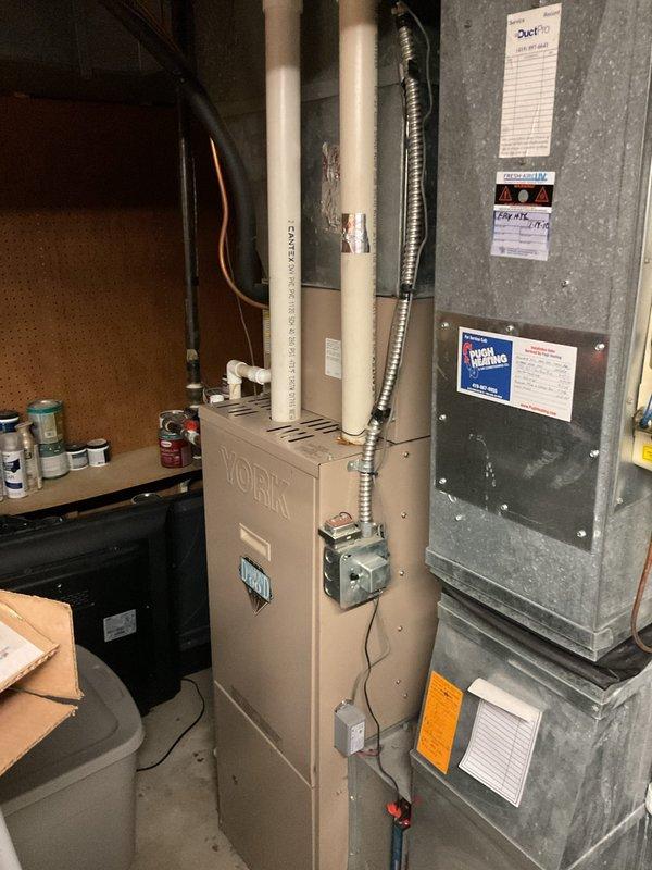 Conducted comprehensive assessment of existing York HVAC system for replacement estimate. Evaluated indoor furnace unit located in basement mechanical room and outdoor York condensing unit positioned on exterior grade. Documented current equipment configuration including gas furnace with PVC venting, electrical connections, refrigerant line sets, and condensate drainage. Photographed both indoor and outdoor components to record existing installation conditions, equipment placement, and utility connections for replacement planning purposes.
