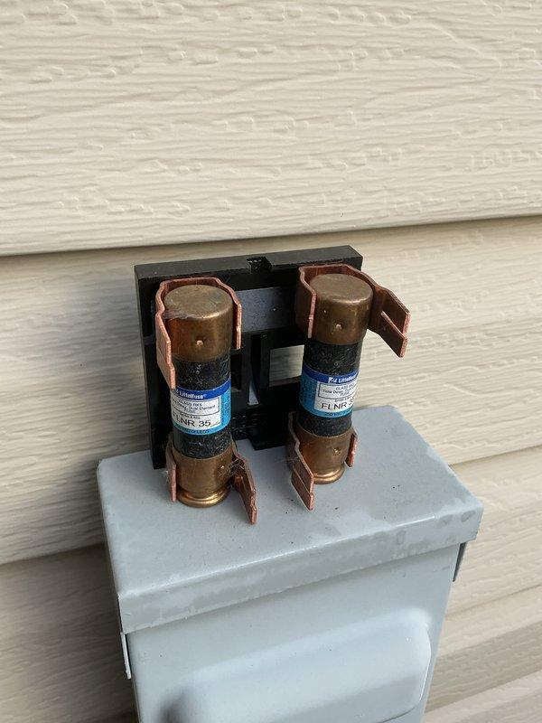 Completed recurring cooling maintenance on outdoor HVAC unit. Upon inspection, found heavily soiled air filter with significant accumulation of dirt, dust, and debris requiring immediate attention. Verified electrical connections and fuse assembly in good working condition, with both fuses properly seated and functioning within normal parameters.