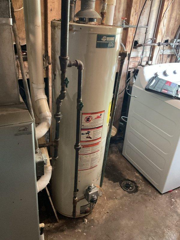 Conducted comprehensive assessment of existing water heater system in residential basement utility area. Documented current installation including tall cylindrical water heater with associated supply and discharge piping configurations. Evaluated existing plumbing connections, including multiple PVC and metal pipe runs, and assessed clearance requirements relative to adjacent heating equipment and mechanical systems. Inspected mounting location, floor drain accessibility, and venting arrangements. Prepared detailed estimate for complete water heater replacement including removal of existing unit, installation of new water heater with code-compliant connections, and proper integration with existing plumbing infrastructure.