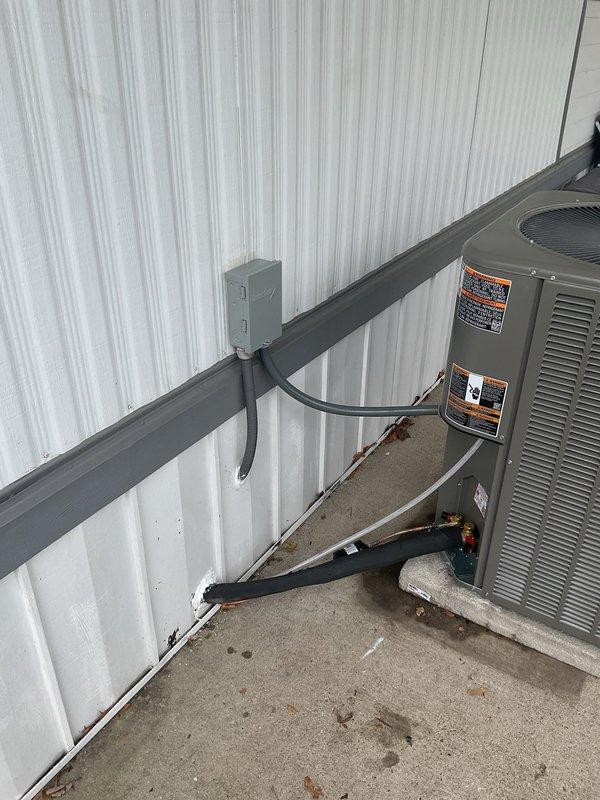 Completed full HVAC system replacement at mobile home installation. Installed new 14 SEER 2-ton condensing unit on concrete pad with 70,000 BTU downflow 80% efficiency gas furnace and matching coil cabinet rated for mobile home applications. Ran new 3/4" x 30' refrigerant line set, installed new roof jack on 4/12 pitch roof positioned 8" down from flashing, and mounted new electrical disconnect with whip. Pulled new thermostat wire to existing Honeywell T-9 unit and connected common wire for proper operation. All equipment tested and verified operational upon completion.