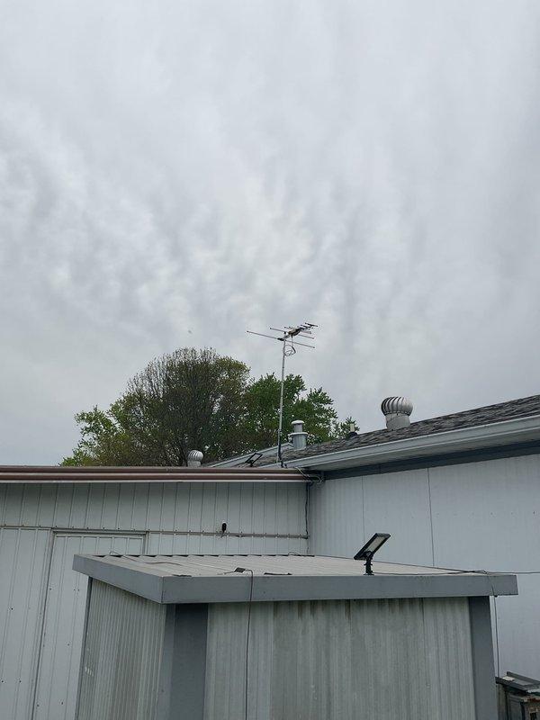 Completed full HVAC system replacement at mobile home installation. Installed new 14 SEER 2-ton condensing unit on concrete pad with 70,000 BTU downflow 80% efficiency gas furnace and matching coil cabinet rated for mobile home applications. Ran new 3/4" x 30' refrigerant line set, installed new roof jack on 4/12 pitch roof positioned 8" down from flashing, and mounted new electrical disconnect with whip. Pulled new thermostat wire to existing Honeywell T-9 unit and connected common wire for proper operation. All equipment tested and verified operational upon completion.