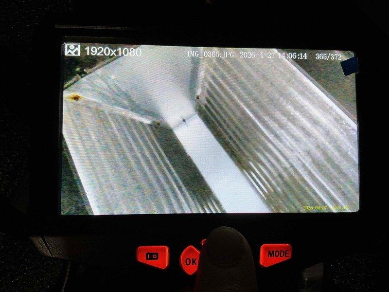 Responded to air conditioning service call that was rescheduled due to weather conditions. Performed comprehensive A/C tune-up and system inspection. Utilized borescope inspection camera to examine condenser coil fins and internal ductwork components. Documentation revealed significant dirt accumulation and discoloration on condenser coil fins, indicating reduced heat transfer efficiency. Interior ductwork inspection showed moisture presence and surface discoloration on pipe walls. Captured detailed photographic evidence of system conditions for service records.