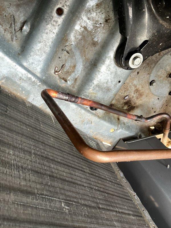 Responded to air conditioning repair call and performed system diagnostics. Upon inspection, discovered severely corroded copper refrigerant lines at the condenser coil connection points, exhibiting heavy oxidation and deterioration that compromised system integrity. The refrigerant tubing showed significant weathering with mottled patina throughout, particularly at joint locations where leaks were likely occurring.

Replaced failed filter-drier assembly with new Parker 404L model compatible with system refrigerant type. Addressed compromised refrigerant lines by cutting out corroded sections and installing new copper tubing with proper brazing techniques. Repaired connections at condenser coil to ensure leak-free operation. Pressure tested system to verify integrity of all repairs and connections. Evacuated system to proper vacuum levels, then recharged with appropriate refrigerant to manufacturer specifications. Verified proper system operation with temperature differential readings 