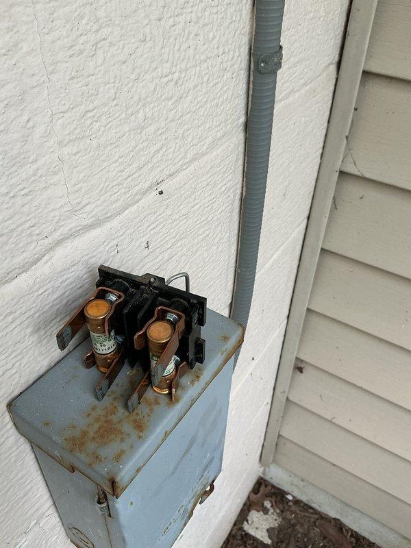 Completed annual air conditioning tune-up and preventative maintenance on 29-year-old cooling system. Inspected outdoor disconnect box and electrical components, noting visible weathering and rust staining consistent with age; all electrical connections remain functional and secure. Unit operational upon completion of scheduled maintenance service.