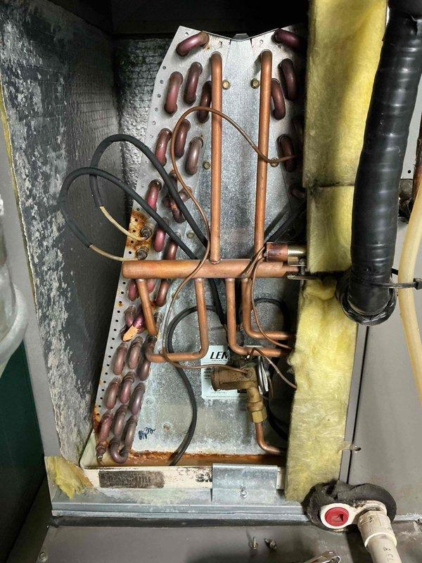 Completed comprehensive preventative maintenance tune-up on aging Lennox outdoor condensing unit located in backyard. System is over 10 years old and showing typical signs of wear including oxidized copper refrigerant lines, deteriorated cabinet interior coating, and weathered components. Performed standard maintenance protocol including inspection of evaporator coil assembly, heat exchanger, copper tubing connections, brass fittings and valves, electrical connections, and condenser unit exterior components. Verified proper operation of all mechanical and electrical systems, checked refrigerant line integrity, and confirmed unit functionality.