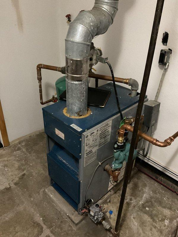 Conducted comprehensive boiler system assessment for existing customer, documenting current equipment condition and configuration. Evaluated blue residential boiler unit with associated copper piping, teal expansion tank, isolation valves, and galvanized venting system. Photographed all major components including plumbing connections, safety devices, and mechanical room layout to provide accurate estimate for replacement or repair recommendations.