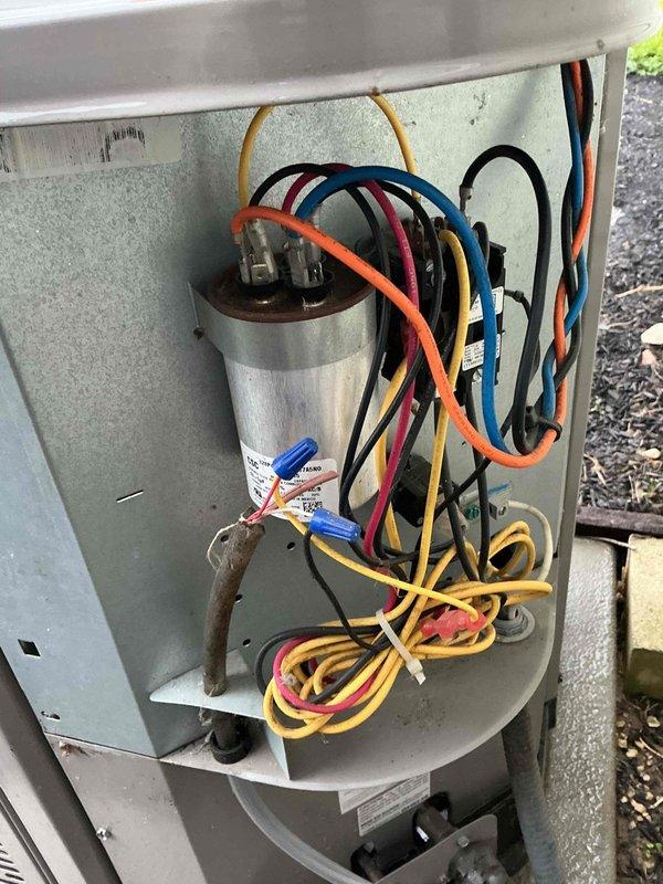 Completed spring maintenance and tune-up on a 3-year-old air conditioning system. Inspected and verified proper operation of electrical disconnect box with cartridge fuses, checked capacitor connections and wiring harness integrity, and documented system condition through photos. All components found in good working order with no immediate repairs needed.