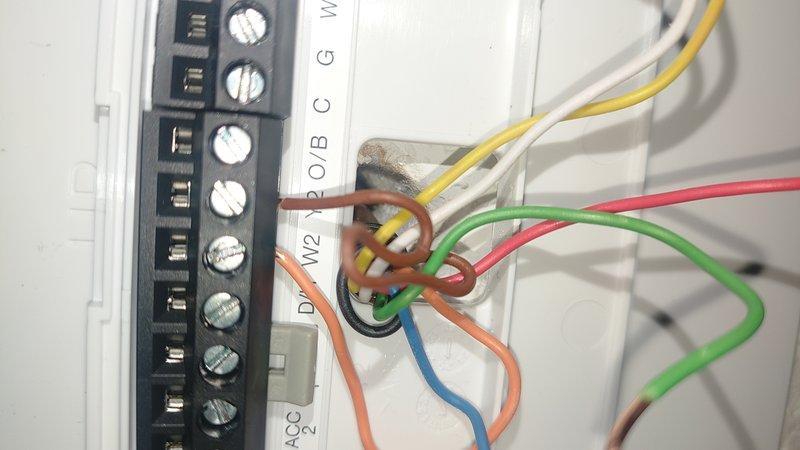 Responded to third service call for non-functional thermostat following new HVAC system installation. Verified all terminal connections at thermostat base including W2, O/B, C, G, W, Y, and ACC wiring points. Performed diagnostic testing with digital multimeter to confirm thermostat malfunction and replaced defective unit to restore heating operation.
