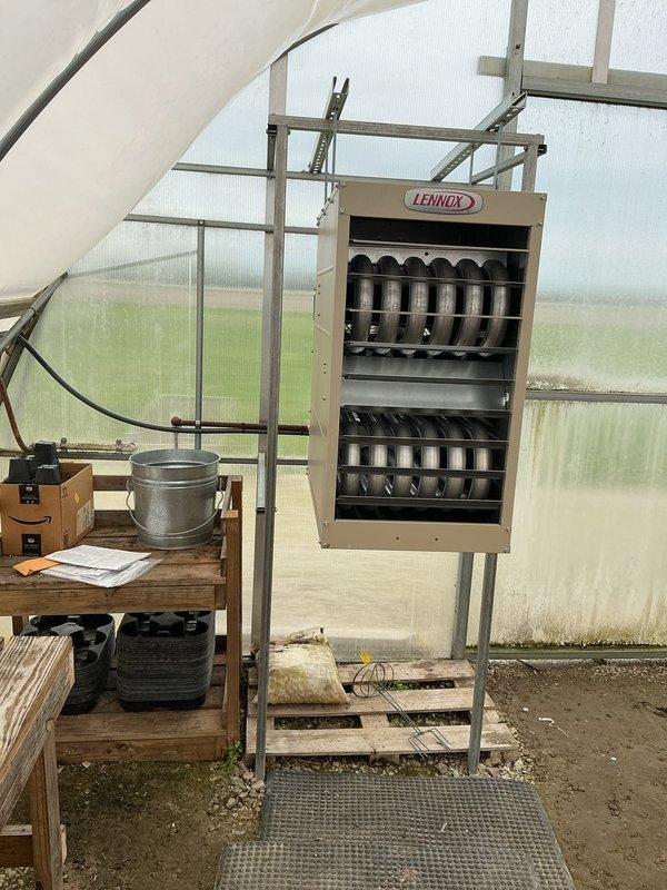 Installed Lennox commercial unit heater in greenhouse facility to provide climate control for agricultural operations. Unit was mounted on metal support frame with wooden pallet base over gravel flooring, including installation of all necessary electrical connections, gas piping, venting components, and digital thermostat control panel. System was tested and verified operational upon completion.