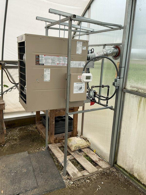 Installed Lennox commercial unit heater in greenhouse facility to provide climate control for agricultural operations. Unit was mounted on metal support frame with wooden pallet base over gravel flooring, including installation of all necessary electrical connections, gas piping, venting components, and digital thermostat control panel. System was tested and verified operational upon completion.