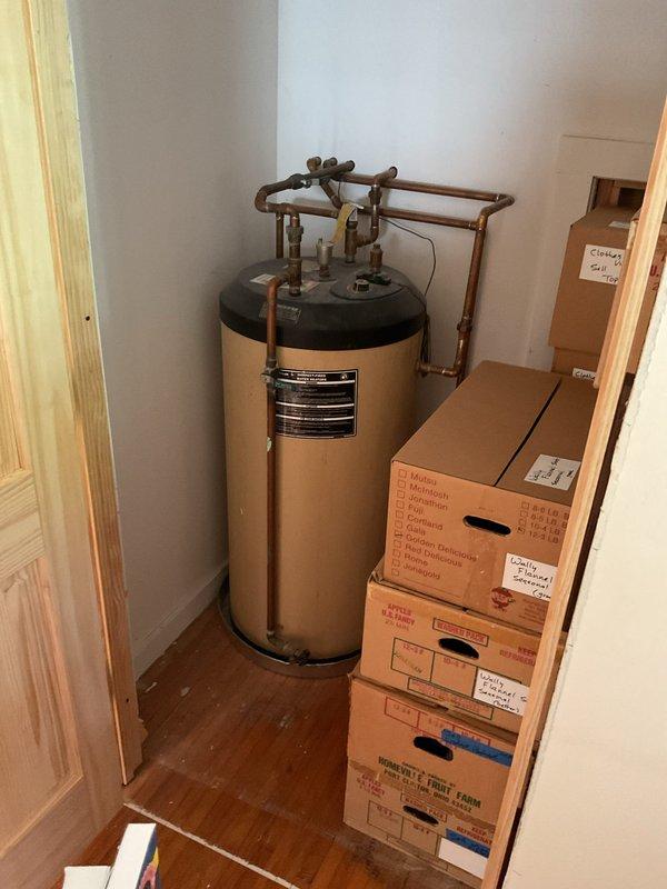 Completed comprehensive boiler system estimate for existing hydronic heating installation featuring expansion tank, multi-zone copper piping network, and integrated water heating components. Documented current system configuration including PVC venting, zone valving, control mechanisms, and all mechanical connections to provide accurate replacement specifications and equipment recommendations.