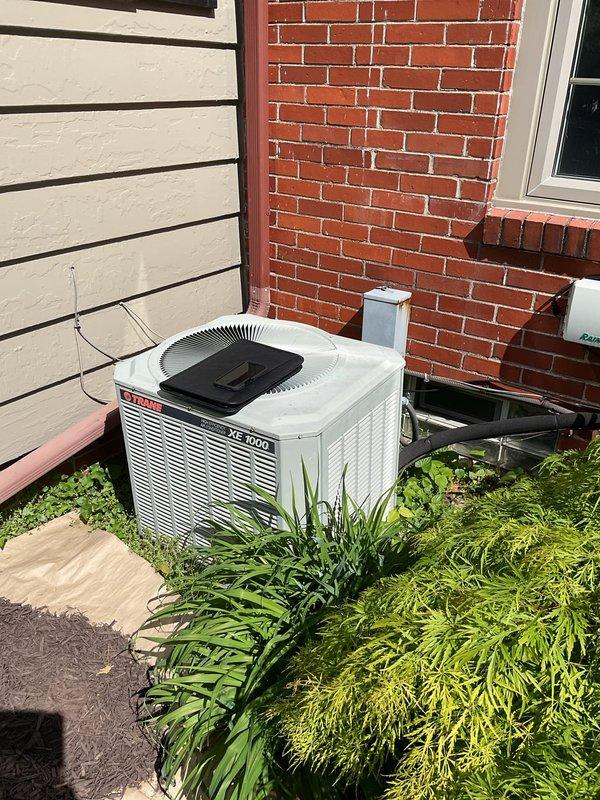 Conducted comprehensive assessment of existing HVAC system for complete air conditioning replacement. Evaluated outdoor Bryant XC 1000 condensing unit positioned on exterior pad against residential brick wall, documenting current equipment specifications and installation conditions. Inspected indoor air handler and associated components in basement mechanical room, including existing Aprilaire whole-house humidifier, ductwork connections, and refrigerant line routing through concrete block foundation. Photographed equipment nameplate data, electrical connections, and mechanical room layout to develop accurate replacement specifications. Assessed accessibility for equipment removal and new installation, noting exterior clearances around outdoor unit and basement workspace constraints. Documented refrigerant line penetrations, condensate drainage routing, and existing electrical service to outdoor unit. Prepared detailed estimate for complete air conditioning system replacement including