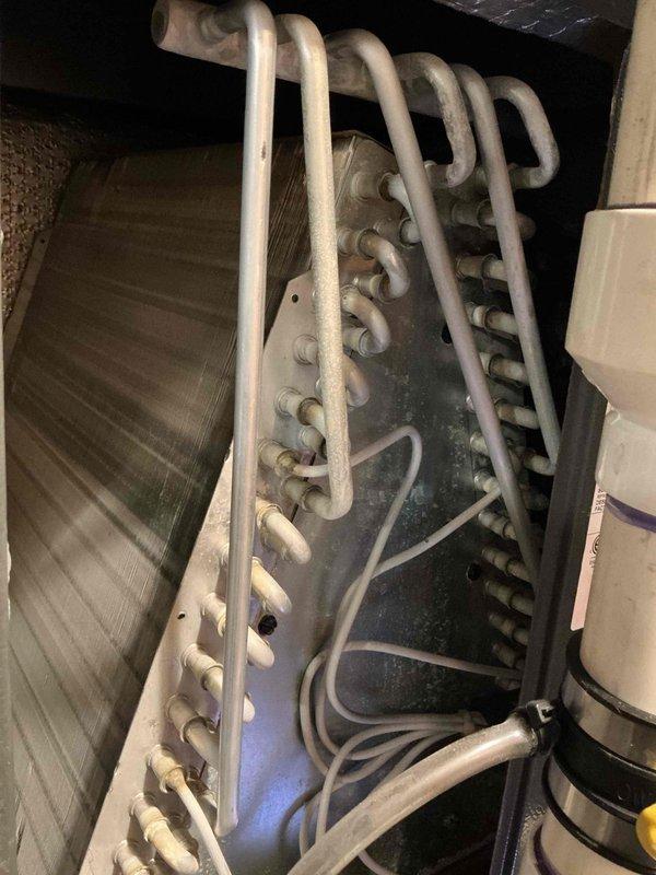 Completed comprehensive cooling maintenance on 10-year-old air conditioning system. Performed thorough inspection of evaporator coil assembly, which revealed moderate dust accumulation and biological growth on coil fins requiring attention. Documented system condition using inspection camera to assess internal components, confirming coil discoloration and debris buildup that could impact heat transfer efficiency. Inspected heat exchanger U-bend copper tube configuration, manifold connections, and air handler assembly for proper operation. All electrical connections, wiring routing, and mechanical fasteners were verified secure with no visible defects noted on system components.