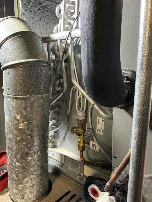 Completed comprehensive air conditioning tune-up on 5-year-old residential HVAC system. Performed standard maintenance protocol including inspection of evaporator coil, refrigerant lines, electrical connections, and condensate drainage system; all components found operating within normal parameters with appropriate condensation present on suction line indicating proper refrigerant charge and system operation.