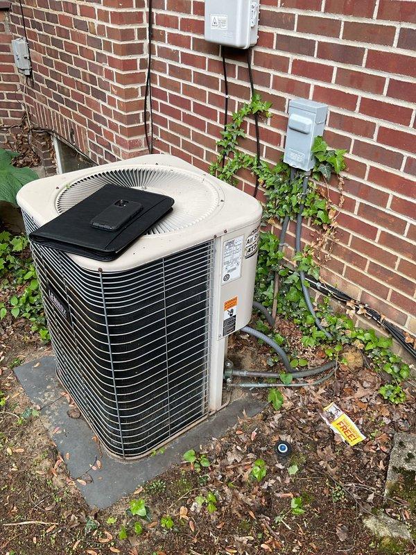 Conducted comprehensive site evaluation for complete air conditioning system replacement at residential property. Assessed existing outdoor condenser unit positioned against brick exterior wall and indoor air handler/evaporator coil assembly located in basement mechanical room. Documented current equipment condition, installation configuration, electrical service connections, refrigerant line routing, condensate drainage system, and ductwork integration. Photographed outdoor unit showing weathering, surrounding vegetation encroachment, and concrete pad condition. Evaluated indoor components including humidifier integration, copper refrigerant lines, and flexible ductwork connections to existing HVAC infrastructure. Provided detailed replacement estimate covering equipment specifications, installation requirements, and system upgrade recommendations to restore optimal cooling performance and efficiency.