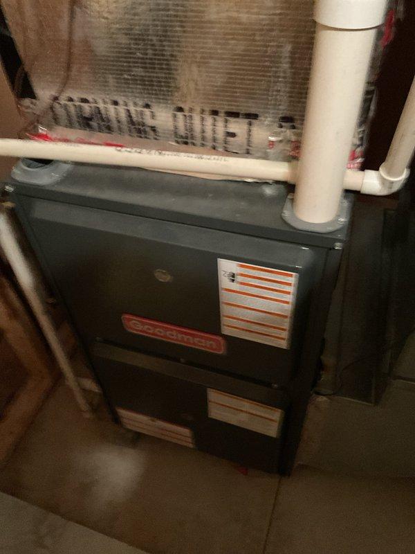 Conducted comprehensive furnace replacement estimate for residential heating system. Evaluated existing dark gray furnace unit with Super Quiet ductwork configuration, assessed current reflective silver duct connections, and inspected white PVC venting and drainage pipe routing. Documented mechanical room layout including proximity to water heater, available clearances, and existing utility connections to provide accurate replacement specifications and installation requirements.