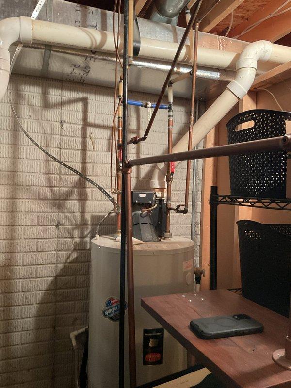 Conducted comprehensive furnace replacement estimate for residential heating system. Evaluated existing dark gray furnace unit with Super Quiet ductwork configuration, assessed current reflective silver duct connections, and inspected white PVC venting and drainage pipe routing. Documented mechanical room layout including proximity to water heater, available clearances, and existing utility connections to provide accurate replacement specifications and installation requirements.