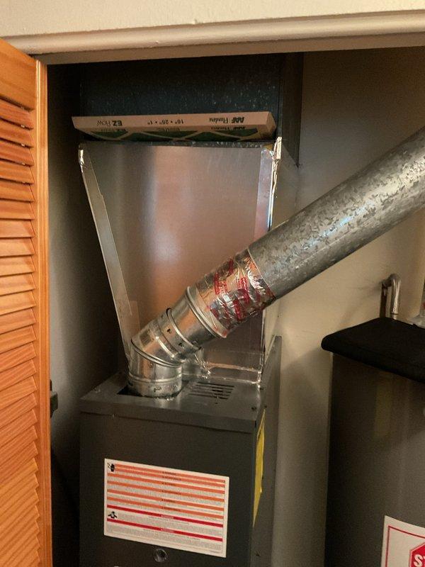 Conducted on-site evaluation of existing Goodman furnace installation in residential utility closet to provide replacement estimate. Customer initially requested air conditioning system estimate but expressed interest in complete HVAC system replacement. Documented current equipment configuration including furnace unit, ductwork connections, condensate pump assembly, and adjacent water heater. Photographed existing installation showing metallic supply plenum, insulated ductwork with visible wear and discoloration, gas line connections, and confined installation space with louvered access door. Assessed equipment condition, spatial constraints, and utility connections to prepare comprehensive replacement options for both standalone AC unit and full heating/cooling system upgrade.