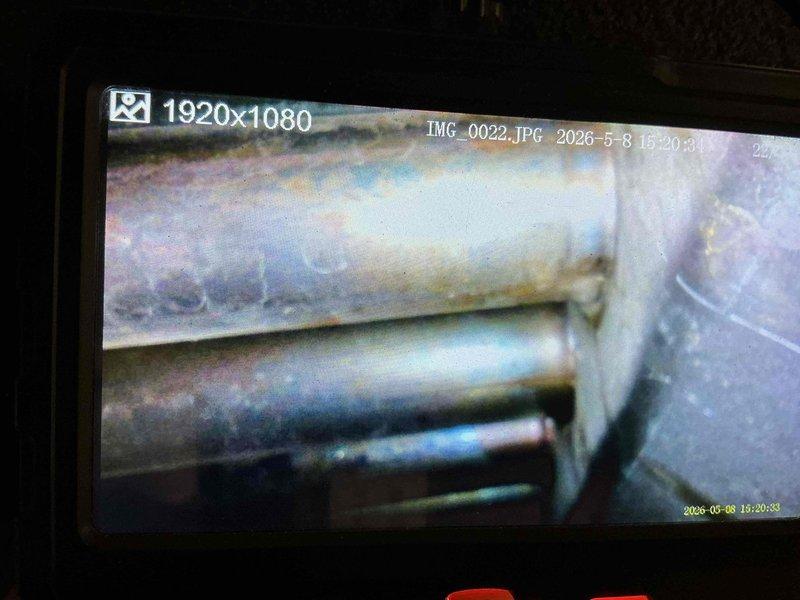 Performed pre-sale inspection of furnace system at buyer's request. Conducted visual examination of unit components, heat exchanger integrity, and burner assembly. Utilized inspection camera to assess internal heat exchanger condition and flue pipe surfaces for signs of corrosion, rust, or deterioration. Documented findings with photographic evidence of piping condition and internal components showing age-related wear and oxidation on metal surfaces.