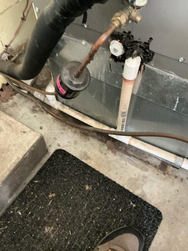Performed scheduled cooling maintenance on 5-year-old residential air conditioning system. Inspected indoor air handler unit in basement, checking refrigerant lines, condensate drain system, and all electrical connections. Evaluated outdoor condenser unit, noting significant debris accumulation on coil fins and surrounding pad. Cleaned condenser coils to remove dirt, dust, and organic material buildup affecting heat transfer efficiency. Cleared leaves, mulch, and vegetation from concrete pad and unit base to ensure proper airflow and drainage. Verified all mechanical components, refrigerant piping insulation, and PVC condensate lines for proper operation and integrity. System operational upon completion of maintenance service.