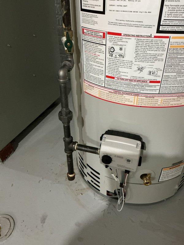 Responded to service call for 26-year-old Bradford White gas water heater experiencing active leak. Upon inspection, confirmed unit had exceeded its expected service life and was no longer functioning reliably. Documented existing installation configuration including copper supply line connections, galvanized vent piping, and gas valve assembly with control unit mounted to tank exterior. Photographed current setup showing top connections with brass fittings, flue arrangement, and overall equipment condition in basement utility area. Provided customer with comprehensive quote for complete water heater replacement including new gas-fired unit, necessary code-compliant connections, and proper venting system to resolve ongoing leak issue and restore hot water service.