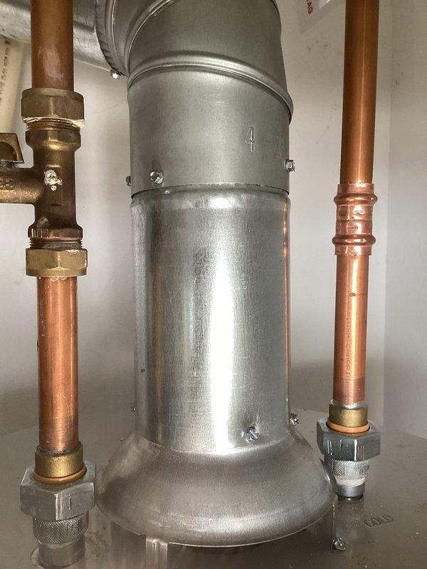 Responded to callback for water heater installation that failed city inspection due to improper piping configuration. Corrected plumbing connections on both hot and cold water lines, ensuring proper installation of copper piping with brass fittings and unions to meet code requirements. Repositioned and secured vent piping connections with appropriate elbow fittings and coupling bands, bringing the entire installation into compliance with municipal plumbing standards for re-inspection approval.
