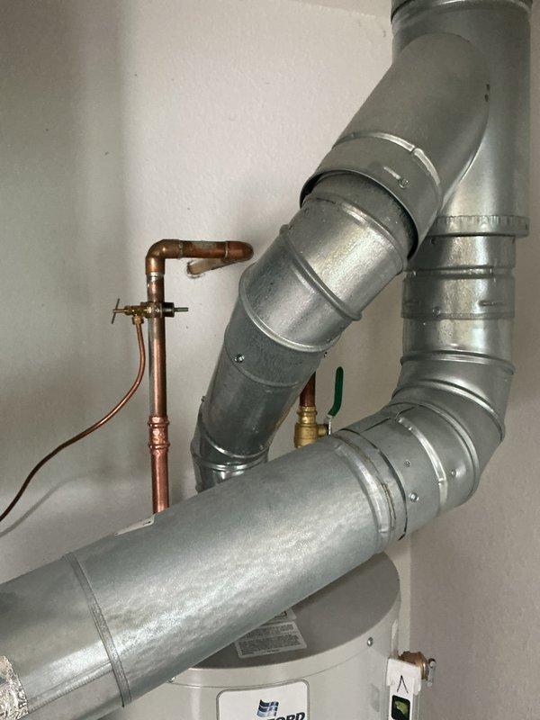 Conducted water heater replacement consultation for 23-year-old residential property. Assessed existing Bradford White conventional tank water heater and surrounding mechanical systems, including ductwork and copper piping configuration. Documented current installation specifications and discussed tankless water heater options with customer to determine optimal replacement solution based on household hot water demand and existing infrastructure compatibility.