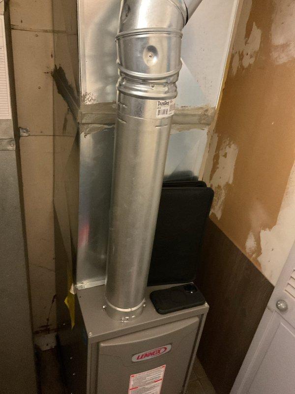 Conducted comprehensive AC system evaluation for equipment replacement. Assessed existing Lennox furnace installation and associated ductwork configuration in utility space, documenting current system condition including aging infrastructure with visible wall deterioration near equipment location. Photographed overhead and front perspectives of air handler positioning, metallic duct routing with elbow connections, and electrical service access point. Provided customer with replacement options and equipment specifications for complete HVAC system upgrade.