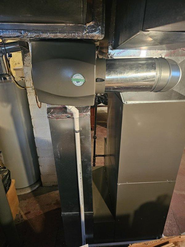 Completed full Lennox split system installation including 96% efficiency upflow furnace conversion from 80% unit with new 2" PVC venting (approximately 60' run to rear of structure for fresh air intake and exhaust). Installed upflow cased evaporator coil, 12-gallon whole-home humidifier with metal housing, and 16x25x5 filter rack. Ran new 3/4" x 30' refrigerant line set to outdoor condensing unit positioned on new equipment pad. Installed 30-amp dedicated electrical circuit (50' run, AWG #10 copper, 2-pole breaker) to condenser with new disconnect box and whip connection. Mounted Honeywell programmable thermostat for system control. Replaced existing water heater with 40-gallon Bradford White unit. System tested and operational per manufacturer specifications with AHRI certification number 215586710.