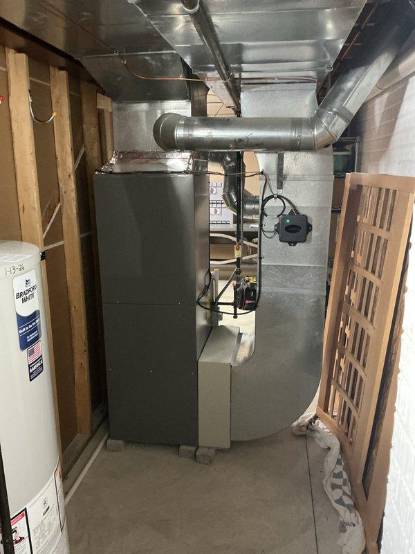 Completed installation of a 14 SEER 3-ton package air conditioning system with new evaporator coil. Installed new 30-foot refrigerant line set connecting the outdoor condensing unit to the indoor coil, ensuring proper insulation and routing. Set outdoor condenser on new concrete equipment pad against exterior wall with cream-colored vinyl siding. Installed new electrical disconnect box with conduit for safe power supply to the unit. Reused existing thermostat to maintain customer preference and reduce installation time. All refrigerant lines were properly brazed, pressure tested, and evacuated before charging the system to manufacturer specifications. Verified proper airflow, temperature differential, and system operation upon startup.