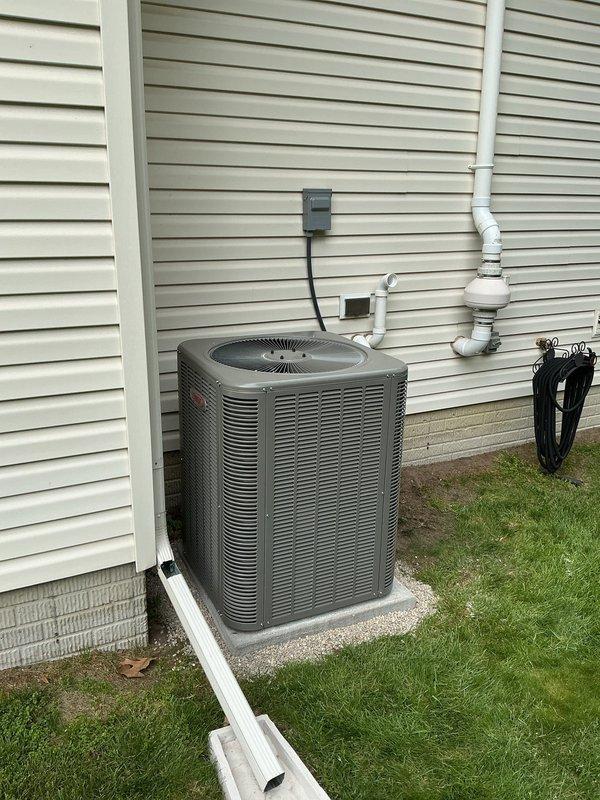 Completed installation of a 14 SEER 3-ton package air conditioning system with new evaporator coil. Installed new 30-foot refrigerant line set connecting the outdoor condensing unit to the indoor coil, ensuring proper insulation and routing. Set outdoor condenser on new concrete equipment pad against exterior wall with cream-colored vinyl siding. Installed new electrical disconnect box with conduit for safe power supply to the unit. Reused existing thermostat to maintain customer preference and reduce installation time. All refrigerant lines were properly brazed, pressure tested, and evacuated before charging the system to manufacturer specifications. Verified proper airflow, temperature differential, and system operation upon startup.