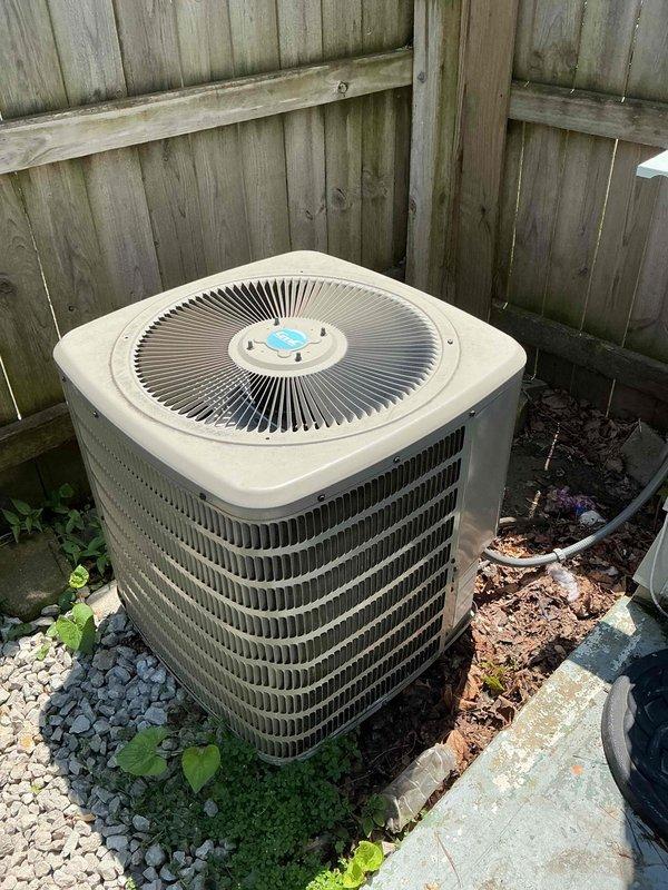 # HVAC Service Report

Responded to no cooling complaint on 4-year-old residential air conditioning system. Upon arrival, accessed electrical compartment and inspected internal components including dual run capacitor, contactor, and associated wiring connections. Verified all electrical connections were secure with proper wire routing observed on red, yellow, purple, and white conductor leads. Evaluated outdoor condensing unit positioned against perimeter fence, noting unit sitting on concrete pad with adequate clearance. Confirmed condenser coil fins intact and fan assembly operational with proper hub configuration. System restored to normal cooling operation following diagnostic evaluation and component verification.