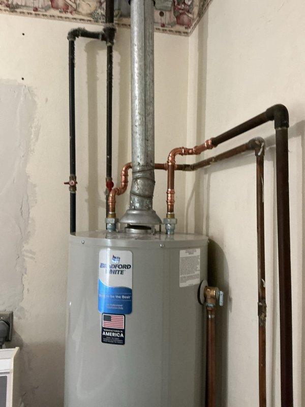 Responded to callback for inspection correction on recently installed Bradford White water heater. Inspector required tank rotation to provide proper clearance for future service and maintenance access. Repositioned water heater to meet code compliance while maintaining all existing plumbing connections, gas line routing, and pressure relief valve placement. Verified all connections remained secure and leak-free after rotation, ensuring unit meets required clearance specifications for service accessibility.