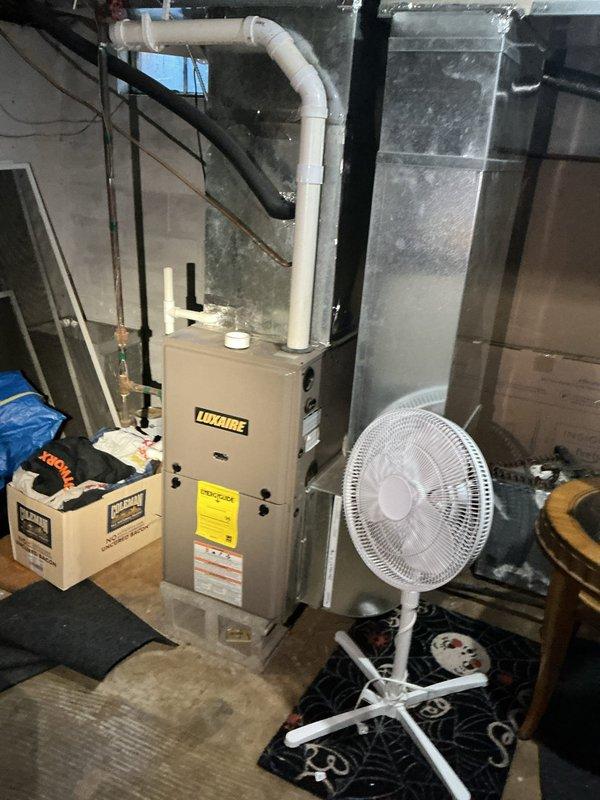 Responded to service call for air conditioning system not blowing cold air at rental property. Accessed property per landlord instructions and performed diagnostic inspection of Luxaire HVAC system located in basement utility area. Documented existing conditions including unit configuration, ductwork, and surrounding mechanical room environment during assessment.