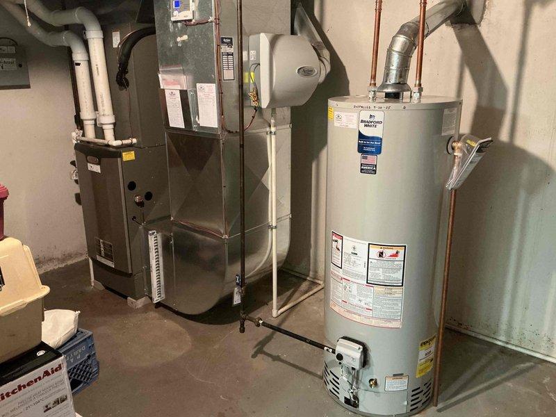 Completed scheduled maintenance on 13-year-old residential air conditioning system. Performed standard cooling season inspection including refrigerant level check, electrical connection verification, condensate drain assessment, and filter evaluation. Documented existing HVAC infrastructure including gas furnace with PVC venting, Aprilaire humidifier mounted to ductwork, and associated mechanical systems in basement utility area. All equipment operating within normal parameters at time of service.