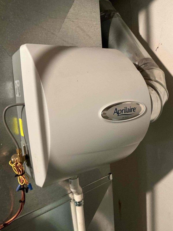 Completed scheduled maintenance on 13-year-old residential air conditioning system. Performed standard cooling season inspection including refrigerant level check, electrical connection verification, condensate drain assessment, and filter evaluation. Documented existing HVAC infrastructure including gas furnace with PVC venting, Aprilaire humidifier mounted to ductwork, and associated mechanical systems in basement utility area. All equipment operating within normal parameters at time of service.