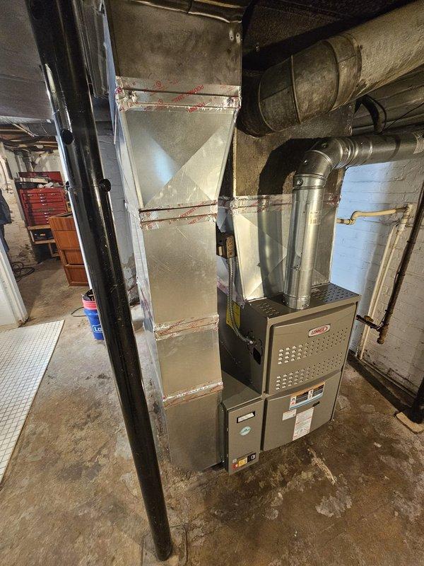 Completed furnace replacement in residential basement, removing existing low boy configuration and installing new upflow 80% efficiency 110,000 BTU furnace unit. Fabricated and installed new return air drop with 5-inch filter rack for improved air filtration. Installed programmable thermostat for enhanced climate control. All ductwork connections properly sealed and secured, system leveled and tested for proper operation upon completion.
